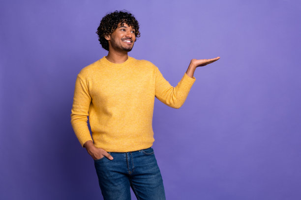 照片中，英俊、漂亮、开朗的男人穿着时髦的黄色衣服，在紫色的背景上留出空间图片下载