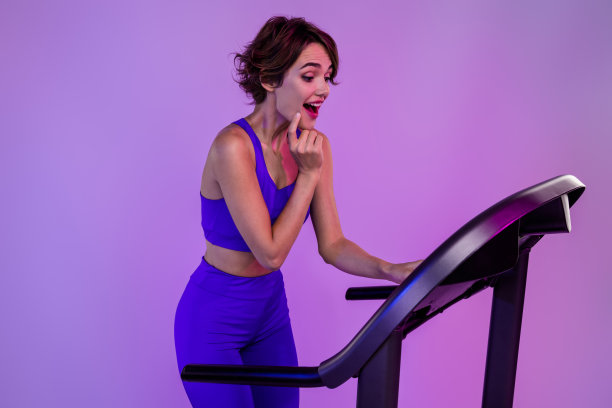 照片兴奋的运动女士教练马拉松运动员尝试新的运动设备调整快速度孤立的霓虹色背景图片下载