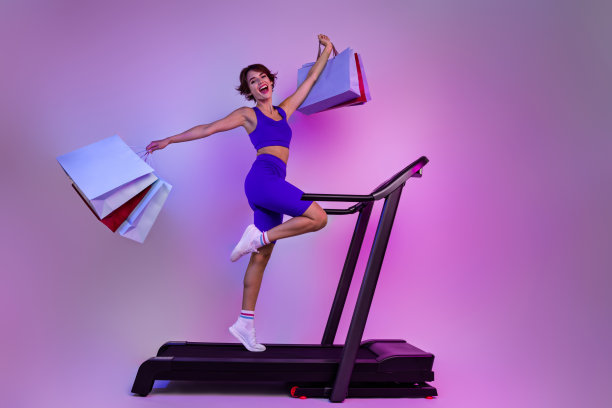 疯狂的购物狂运动女孩的照片感到高兴购买消费主义运动品牌难以置信的销售孤立的霓虹色背景图片下载