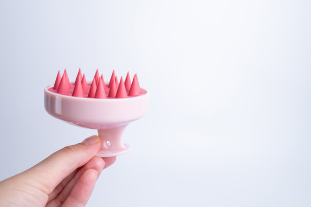 按摩器的头发和头皮的手在浅色背景，特写图片下载