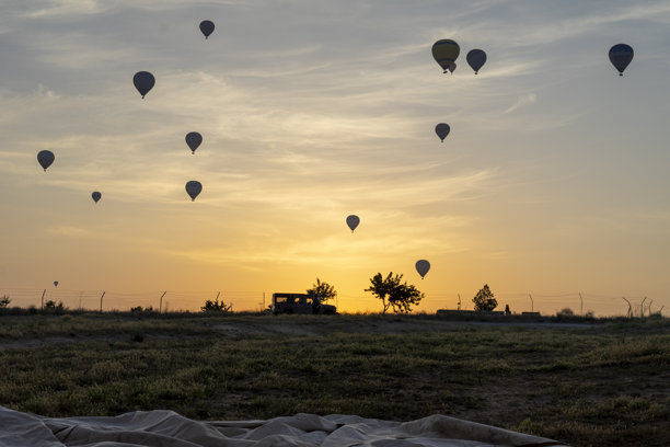 日出时背光拍摄的热气球照片。图片下载