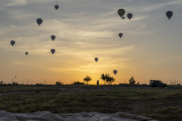 日出时背光拍摄的热气球照片。图片下载