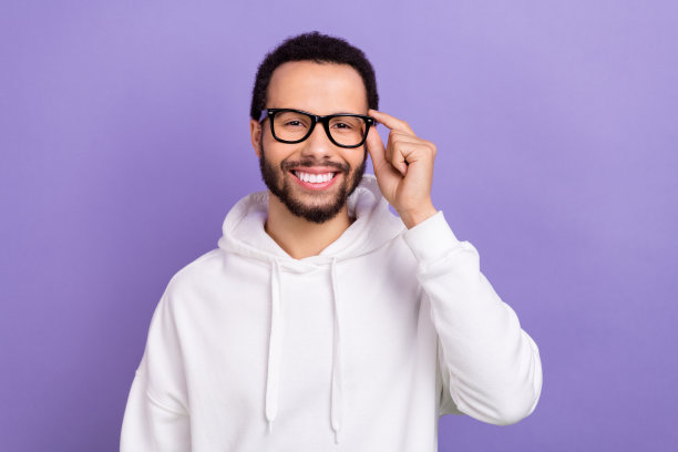 年轻的知识分子商业公司老板的肖像，男人穿着运动衫，触摸眼镜，紫色背景上孤立的宣传横幅图片下载