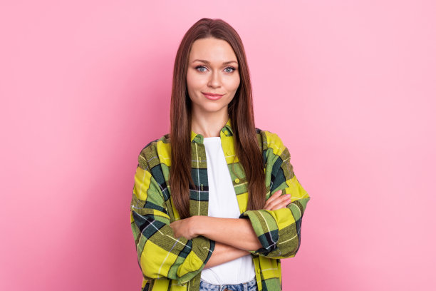 照片中，自信的商务女士穿着格子衬衫，双手交叉，满足于她的办公室管理职业，孤立在粉红色的背景上图片下载