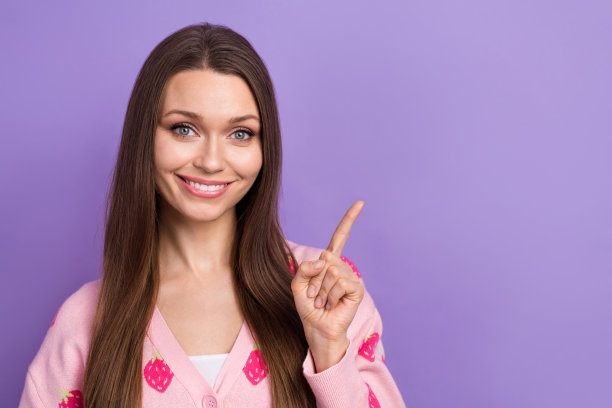 照片的漂亮可爱的女孩穿浆果印花开衫显示手指空白空间孤立的紫罗兰色背景图片下载
