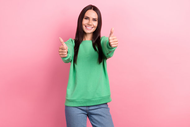 肖像积极愉快的女孩直发穿绿色套衫显示喜欢你的工作隔离在粉红色的背景图片下载