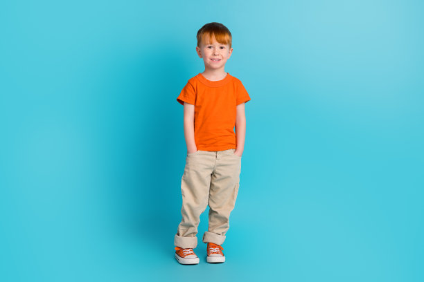 正面小男人的手口袋穿舒适时尚明亮的衣服空间孤立的青色背景的全身照片图片下载