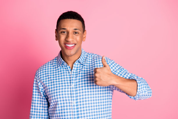时髦酷的家伙穿着格子衬衫的照片显示大拇指向上空的空间孤立的粉红色背景图片下载