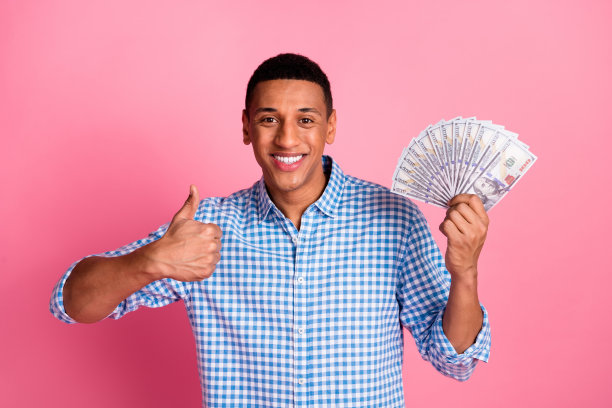 照片时髦的酷家伙穿着格子衬衫上升美元风扇显示拇指向上孤立的粉红色背景图片下载