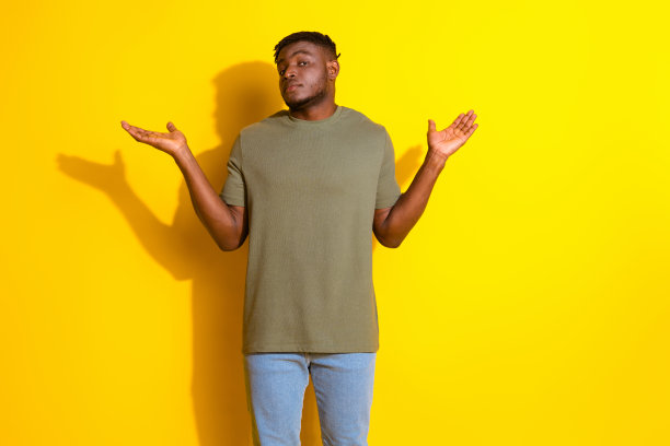 照片中帅气的男人穿着卡其色的时尚衣服，在黄色的背景上失败了图片下载