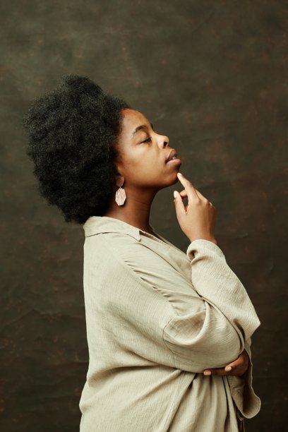 黑人妇女在棕色背景上触摸脸的侧面图片下载