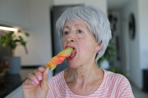 老年妇女焦虑地吃着冰棍图片下载