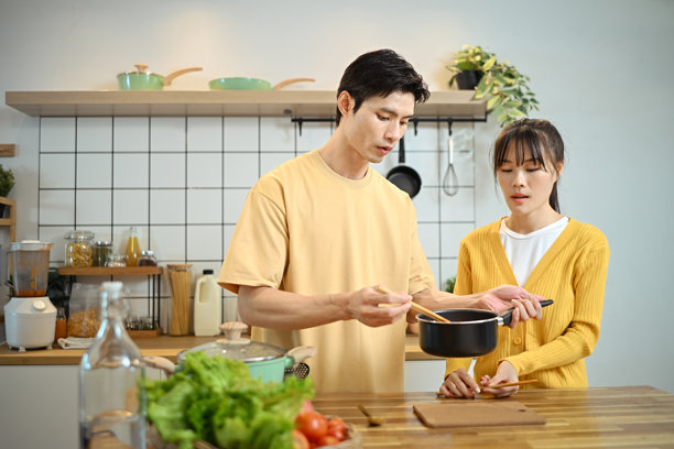 幸福的年轻夫妇在简约的厨房里用新鲜的食材一起准备饭菜图片下载