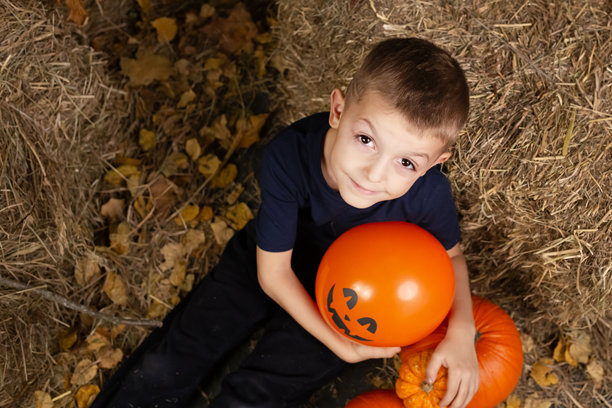描绘快乐的孩子们为万圣节做准备。拿着万圣节南瓜的孩子图片下载