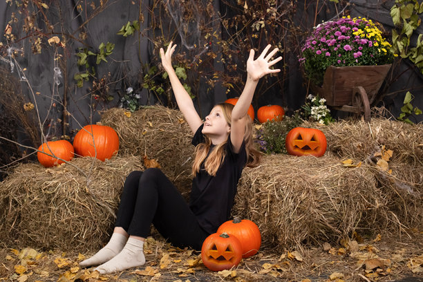 快乐的女孩在万圣节。在室内穿着狂欢节服装的有趣的孩子们。兴高采烈的孩子们玩南瓜和糖果图片下载