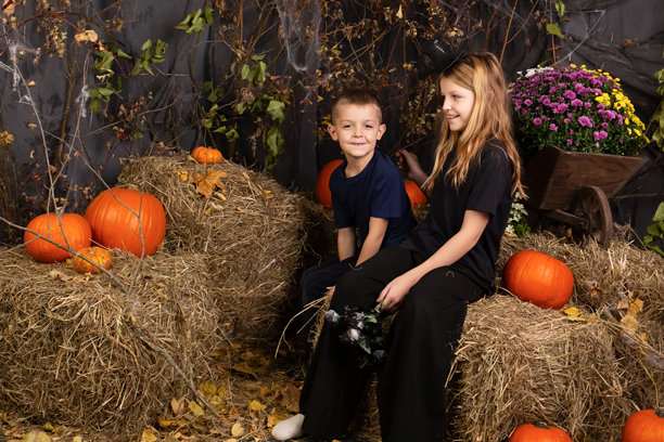 快乐的兄弟姐妹万圣节。在室内穿着狂欢节服装的有趣的孩子们。兴高采烈的孩子们在玩南瓜图片下载