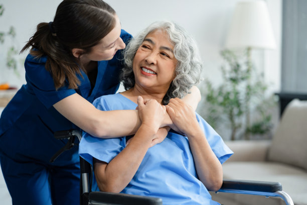 养老理念。护士和她的老年病人坐在轮椅上的照片。图片下载