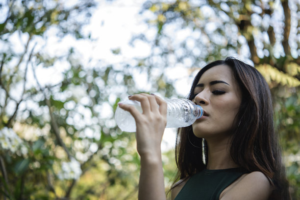 年轻女子喝水壶户外公园游客。亚洲女性饮用水瓶健康人快乐微笑。幸福美丽的亚洲中国女性拿着矿泉水瓶的生活方式图片下载