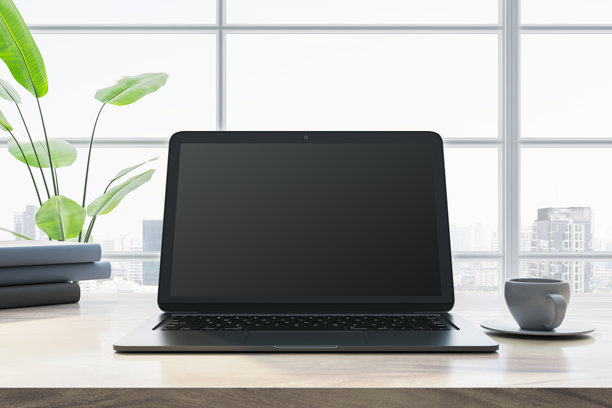 桌子上放着一台现代化的笔记本电脑，窗户很大，可以看到城市的景色。三维渲染图片下载