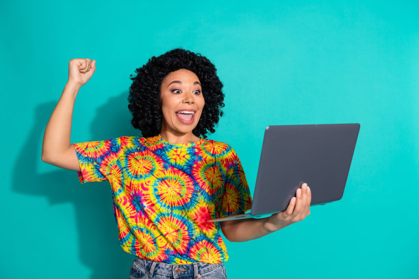 照片可爱的幸运女孩穿着印花t恤赢得游戏现代设备空白空间孤立的绿松石色背景图片下载