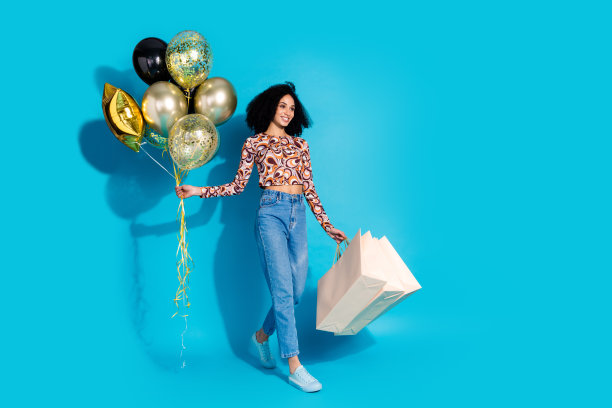 照片中迷人开朗的漂亮女人穿着时髦的衣服走在空旷的空间里，横幅孤立在蓝色的背景上图片下载