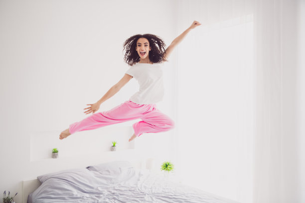 迷人的年轻女子全身照片跳飞超人早上好振动醒来家卧室光白色室内图片下载