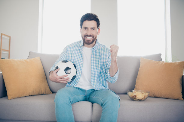 英俊的大胡子的照片独自成熟的成年男子呆在家里的客厅拿着球庆祝冠军最喜欢的球队图片下载