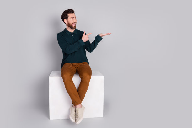 照片中有趣迷人的男人穿着时髦的绿色衣服，在灰色的背景上提供了孤立的空间图片下载