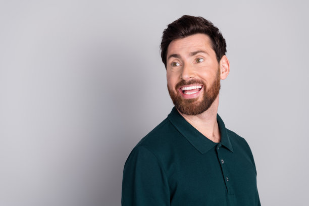 照片中快乐开朗积极的男人穿着时髦的绿色衣服，在灰色的背景上显得空虚孤立图片下载