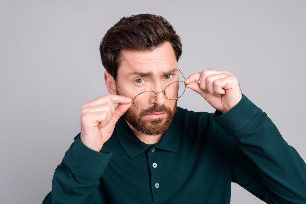 照片中有魅力的英俊男子穿着时尚的衣服，在灰色的背景下看起来很孤立图片下载