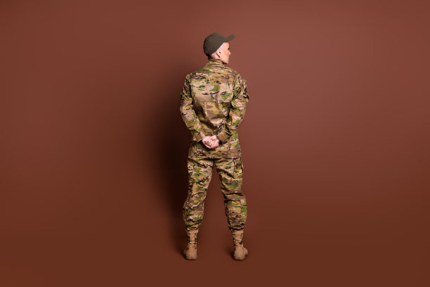 成熟的女军官的全身照片看起来空的空间手臂背后的背视图穿着军服孤立的棕色背景图片下载