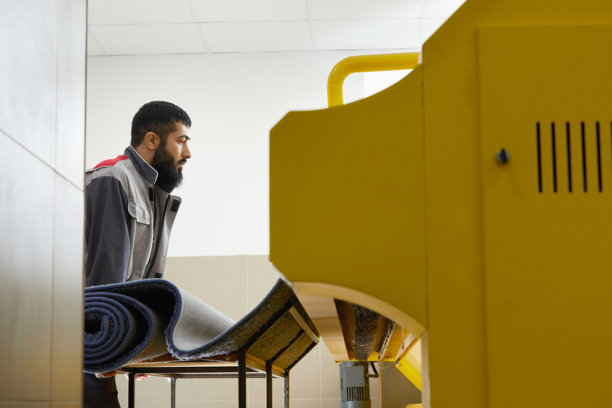 在专业洗衣服务中操作地毯自动清洗机的男子图片下载