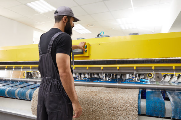 在专业洗衣服务中操作地毯自动清洗机的男子图片下载
