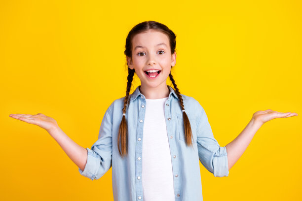 照片中迷人可爱的惊喜女孩穿着时髦的衣服，推荐在黄色背景上孤立的空白空间图片下载