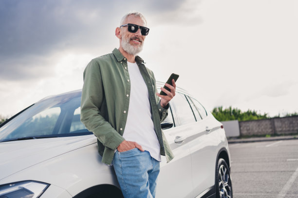 穿着卡其布衬衫的开朗积极的家伙在城市街道外租了一辆现代小工具的照片图片下载