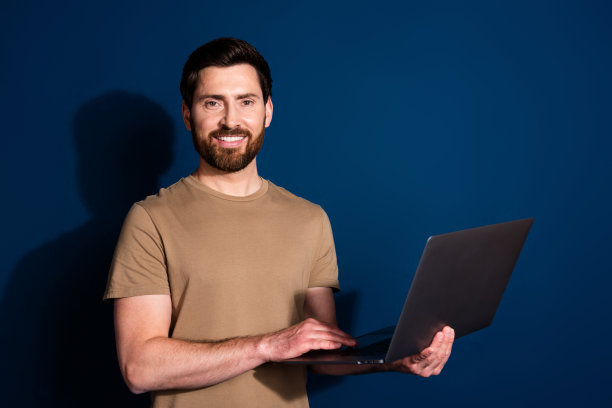 成熟年龄的照片高级it专家程序员黑发男子与上网本在网上工作孤立的深蓝色背景图片下载