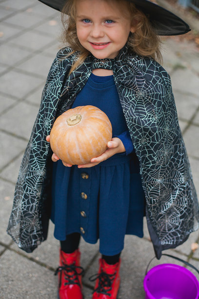 可爱的女孩穿着女巫和德古拉带着南瓜桶图片下载