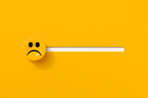 悲伤的脸滑块按钮上的黄色背景图片下载