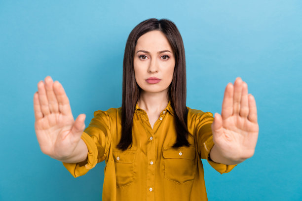 严肃、自信、不开心的女企业主手持否决权的特写照片，与新闻发布会的报道被隔离在蓝色背景上图片下载