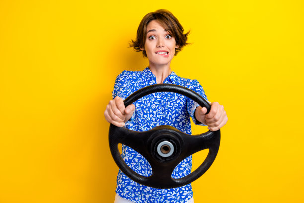 照片时髦的疯狂的女士穿着蓝色时髦的衣服试驾新的自己的汽车公路旅行市中心孤立的黄色背景图片下载