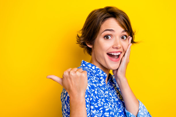 惊讶的美女手臂脸的照片在黄色的背景上表现出很好的反馈特殊命题图片下载