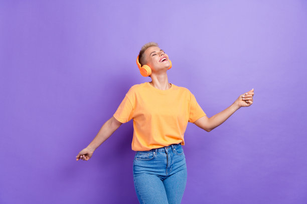 照片好心情好女孩短发穿着黄色t恤享受舞蹈闭上眼睛孤立的紫色背景图片下载