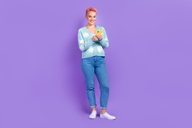 全身尺寸的照片干部年轻积极的企业家流行博主时髦的女孩染成粉红色的头发持有手机孤立的紫色背景图片下载