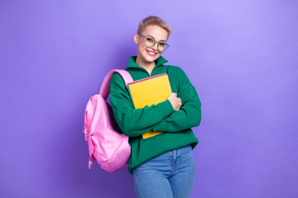 照片中可爱开朗的人笑容满面，双手拿着孤立在紫罗兰色背景上的抄本图片下载