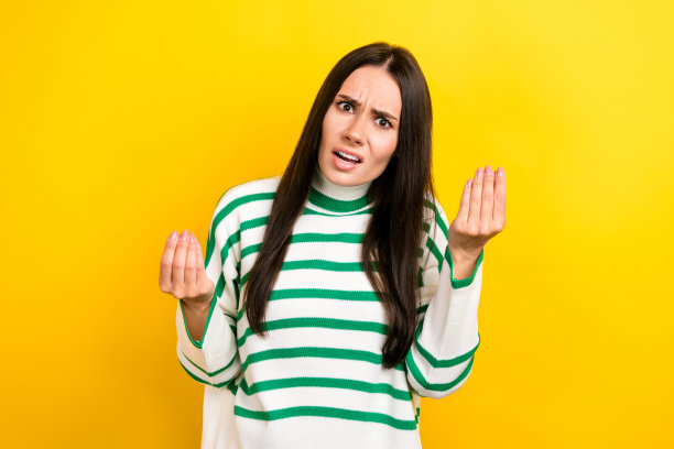 照片中愤怒的女人穿着条纹毛衣，抬起手臂争吵，孤立的黄色背景图片下载