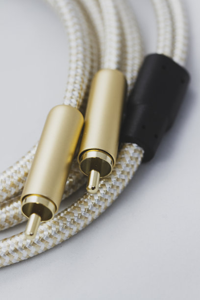 在白色背景下，金色外壳的辅助音频电缆的特写照片图片下载