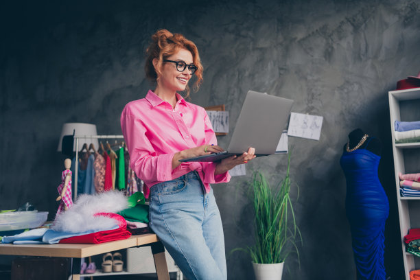 漂亮的年轻设计师女裁缝使用上网本穿衬衫阁楼室内办公室室内的照片图片下载