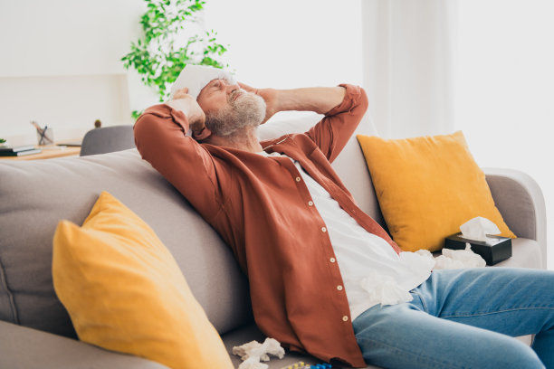 漂亮的退休男子的照片坐在沙发毛巾压缩高温穿棕色衣服现代舒适的室内平坦的室内图片下载