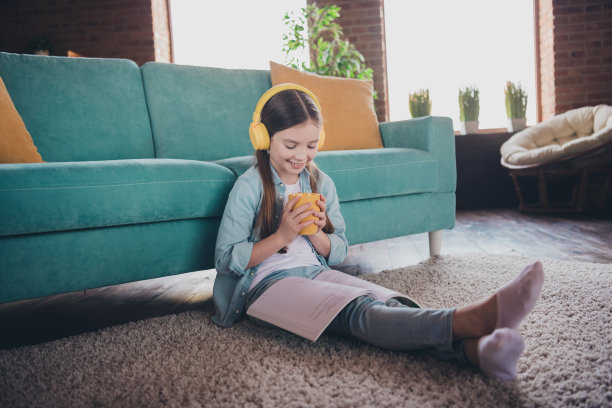 可爱的小女孩的全尺寸照片耳机书杯子穿衬衫阁楼室内公寓室内图片下载