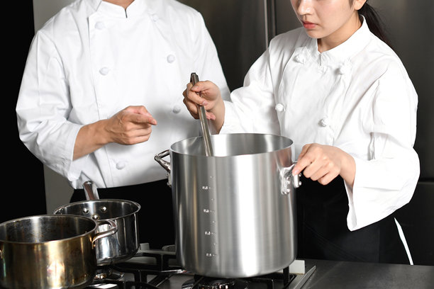 年轻的亚洲女厨师和男厨师正在厨房里聊天图片下载